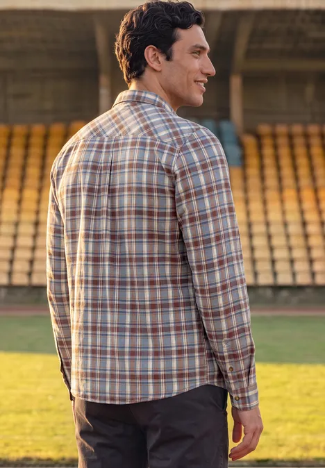 Chemise en flanelle à manches longues à carreaux raw copper red Mann im karierten Hemd steht mit dem Rücken zur Kamera auf einer Stadiontribüne.