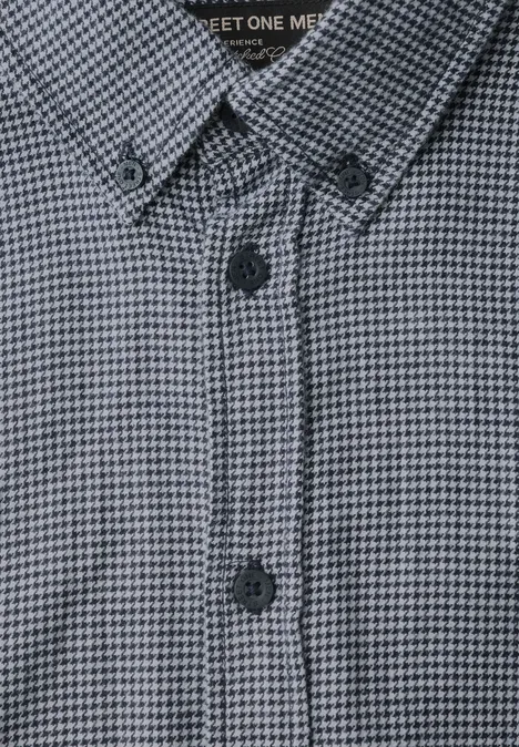 Nahaufnahme eines Hemds mit feinem Hahnentrittmuster in Grautönen, Knopfleiste und Button-down-Kragen.