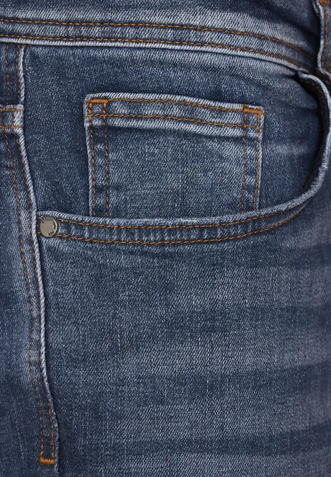 Gros plan sur la poche d’un jean bleu avec coutures.