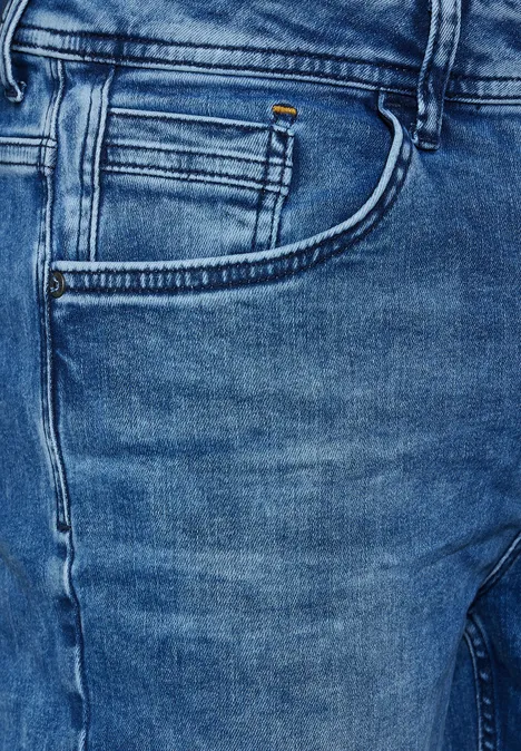 Gros plan sur un jean bleu avec poche visible.
