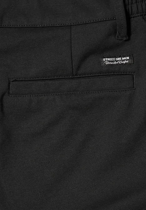 Nahaufnahme einer schwarzen Hose mit eingesetzter Gesäßtasche und kleinem weißen Label über der Tasche.