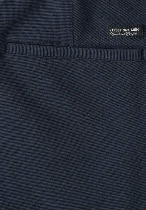 Surface en tissu bleu marine avec poche plaquée et petit label noir 'STREET ONE MEN'.