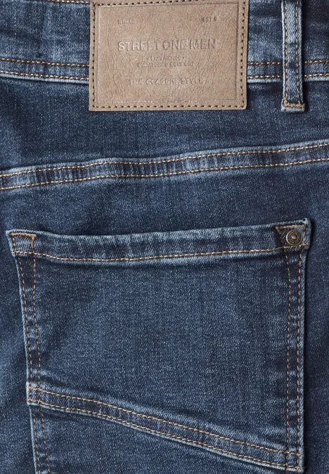 Detailaufnahme einer blauen Jeans mit aufgesetzter Gesäßtasche und Lederpatch.