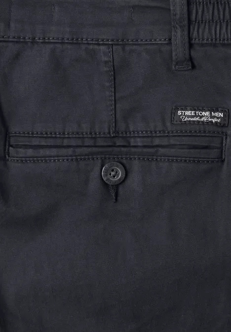Nahaufnahme einer dunkelblauen Herrenhose, Rücktasche mit Knopfverschluss und Markenlabel.