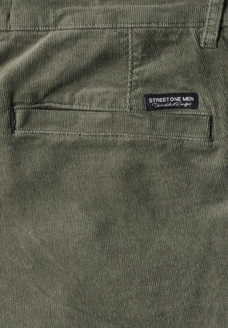Gros plan d'un pantalon homme vert avec poche latérale et étiquette Street One Men.