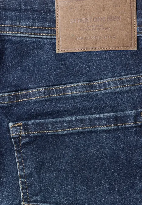 Dunkelblaue Jeans mit sichtbaren Gesäßstaschen und Lederetikett am Bund.