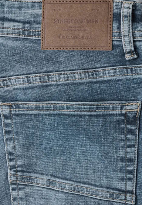 Nahe Aufnahme blauer Jeans mit Lederetikett am Bund und Gesäßtasche.