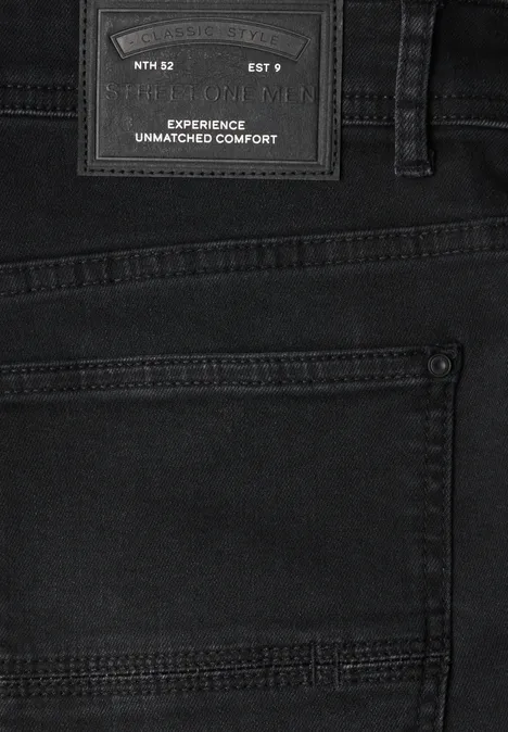 Nahaufnahme einer schwarzen Jeans mit Gesäßtasche und Lederetikett 'Experience Unmatched Comfort'