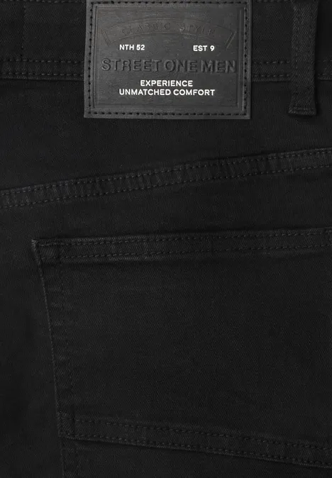Zwarte spijkerbroek met zwart label 'FOR MEN' en tekst 'EXPERIENCE UNMATCHED COMFORT'.