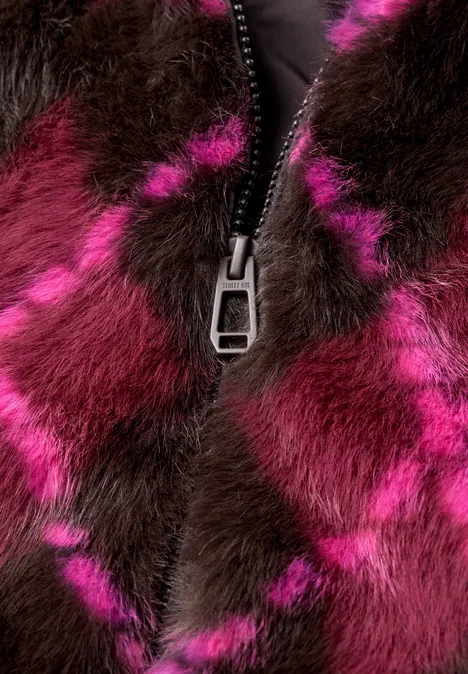 Nahaufnahme eines flauschigen Fellmantels in Pink und Dunkelbraun mit einem silbernen Reißverschluss.
