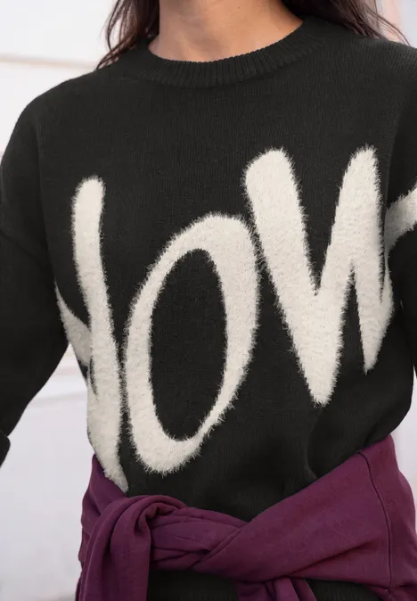 Pullover mit großem Wording Artwork Black Schwarzer Pullover mit weißem Love-Schriftzug, lila Oberteil um die Taille gebunden.