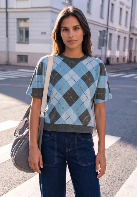 Shirt met gebreide look en argylepatroon loom blue Junge Frau in kariertem Pullover und Jeans steht mit großer Tasche auf sonniger Straßenecke.