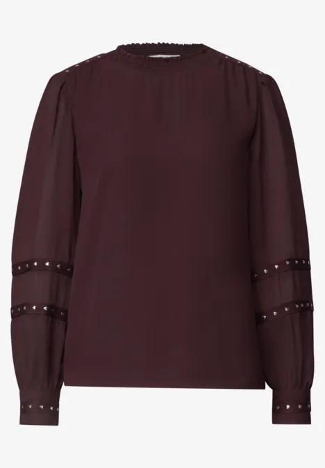Chemisier à manches longues avec des rivets et un col smocké russet red Blouse en mousseline bordeaux à encolure ronde et bandes à rivets sur les manches longues.