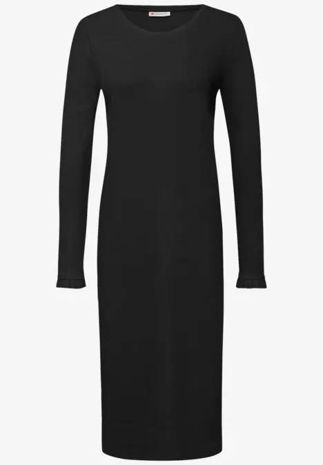 Robe noire à manches longues et col rond, longueur genou.