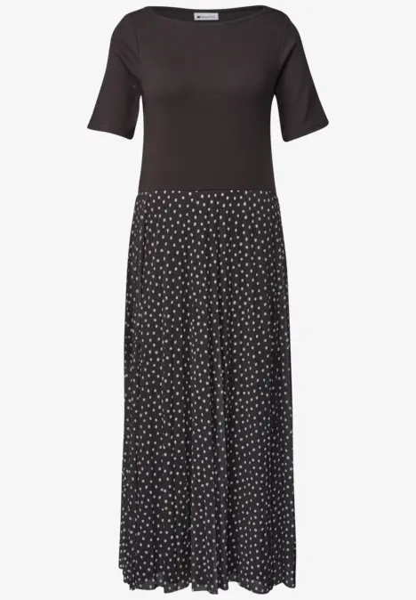 Robe noire à manches mi-longues et jupe fluide à pois blancs.