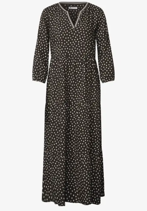 Schwarz-weiß gepunktetes Maxikleid mit V-Ausschnitt, langen Ärmeln und lockerem Fall.
