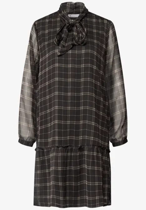 Robe noire à carreaux, manches longues, col noué et taille tombante pour un look décontracté.