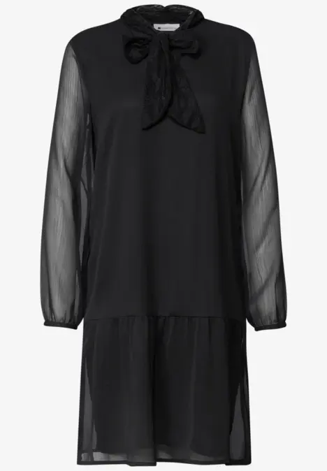Schwarzes, knielanges Chiffonkleid mit transparenten Ärmeln, Rüschen am Saum und Schleifenkragen.
