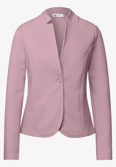 Veste blazer rose clair pour femme, manches longues et fermeture par bouton.