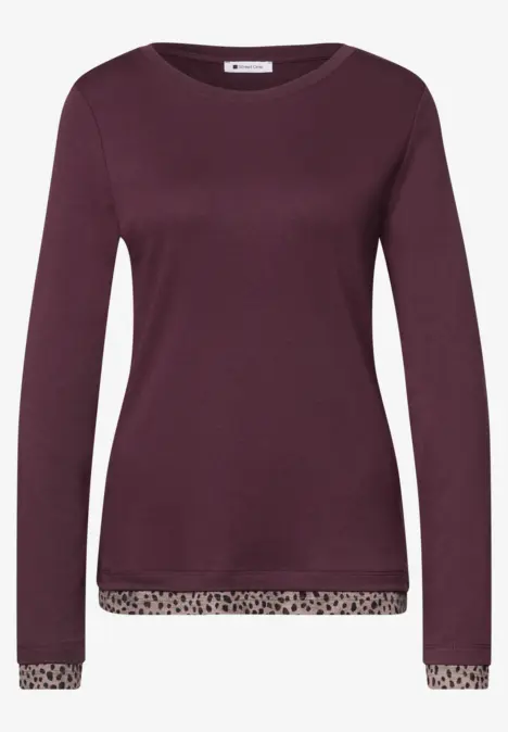 Lila Damenpullover mit langen Ärmeln und dezenten Leopardmusterabschlüssen an Saum und Manschetten.