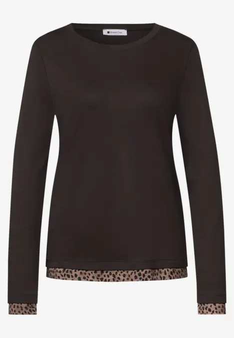 Schwarzes Langarmshirt mit Leopardenbordüre am Saum und Ärmeln.