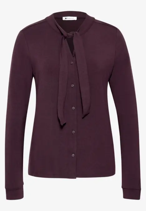 Lila Strickjacke mit Knopfleiste und Schleifenkragen, langärmlig.