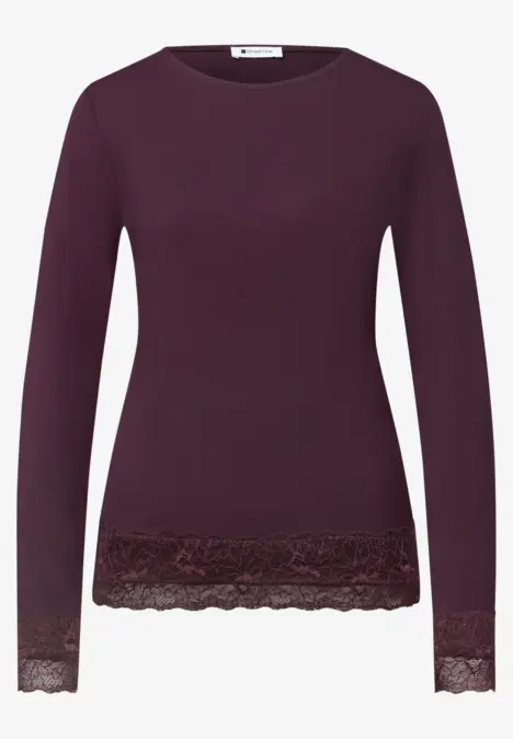 Lila Damenpullover mit langen Ärmeln und Spitzenbesatz am Saum und an den Ärmelbündchen.