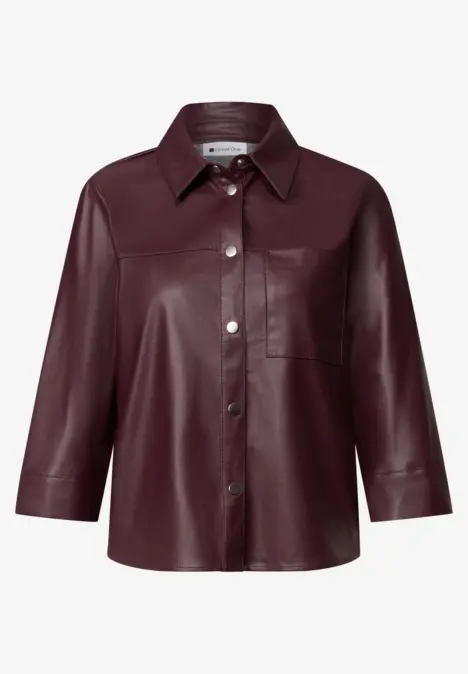 Bordeauxrood leren blouse met 3/4-mouwen, klassieke kraag, knoopsluiting en borstzak.