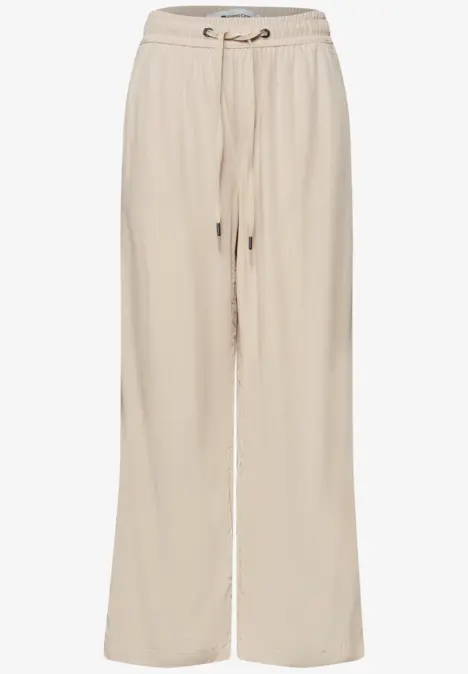 Beige wijde linnen broek met trekkoord in de taille en zijzakken.