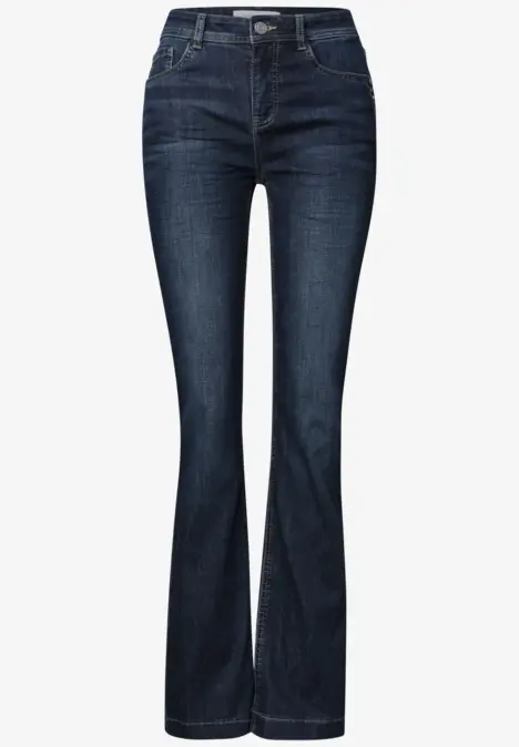 Jean bleu foncé pour femme, taille mi-haute, jambes évasées, coupe près du corps sur les hanches et cuisses.