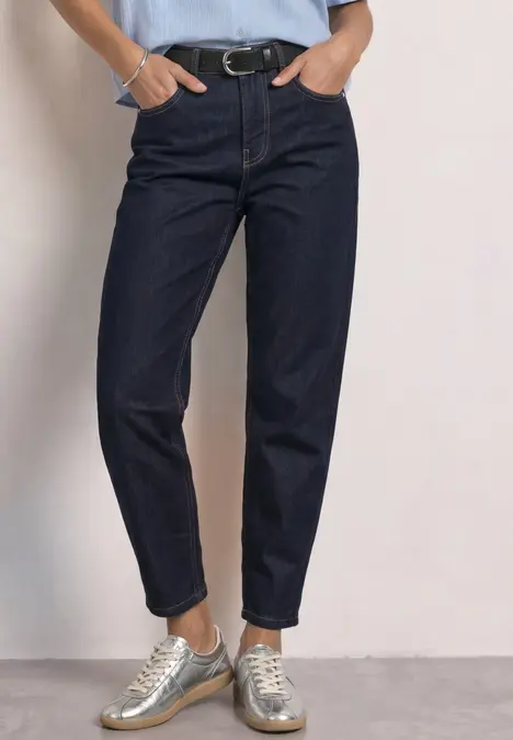 Eng anliegende, hoch taillierte, dunkelblaue Jeans mit lockerem Schnitt und silbernen Sneakern.