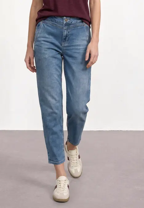 Cowboyjeans in mittlerer Taille und geradem Schnitt, kombiniert mit hellen Sneakern.