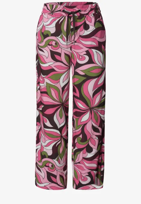 Pantalon large avec motif floral psychédélique rose et vert.