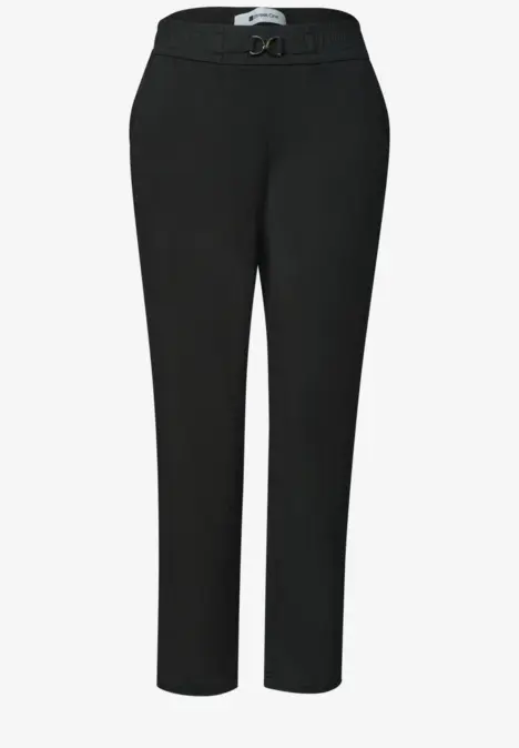 Zwarte pantalon met tailleband, ceintuur en licht taps toelopende pijpen.