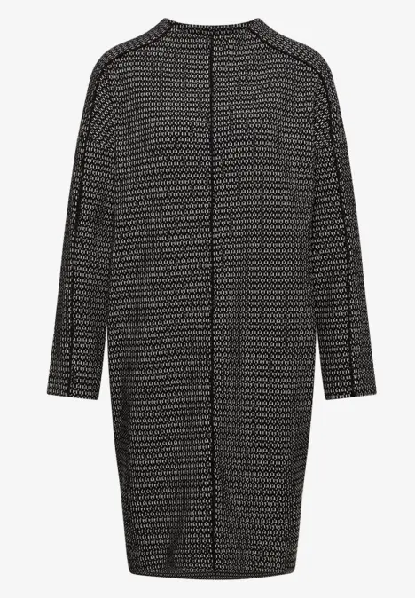 Cardigan long noir à manches longues, motif à petits points blancs, coupe ample arrivant aux genoux.