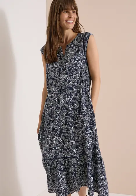 Femme portant une robe longue sans manches à motif cachemire bleu et blanc.