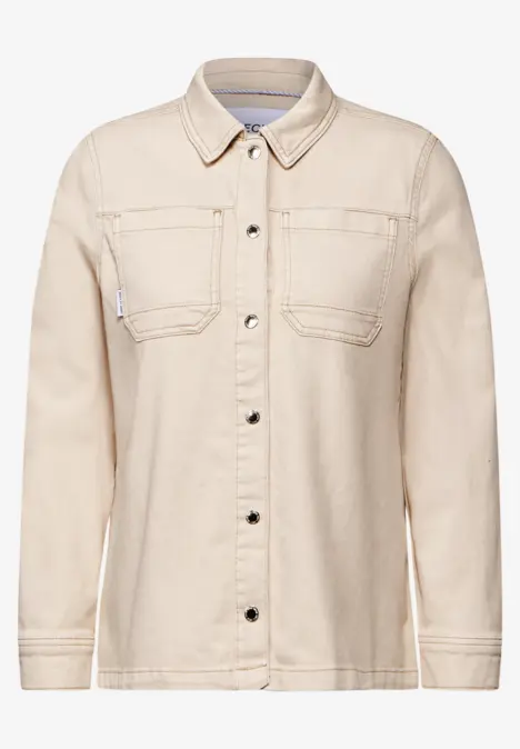 Beigefarbene Jeansjacke mit Knöpfen und Brusttaschen.