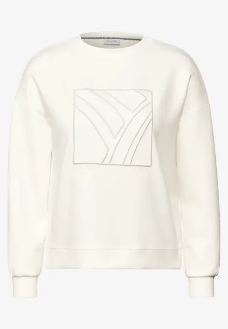 Weißer Pullover mit quadratischem Muster auf der Brust.
