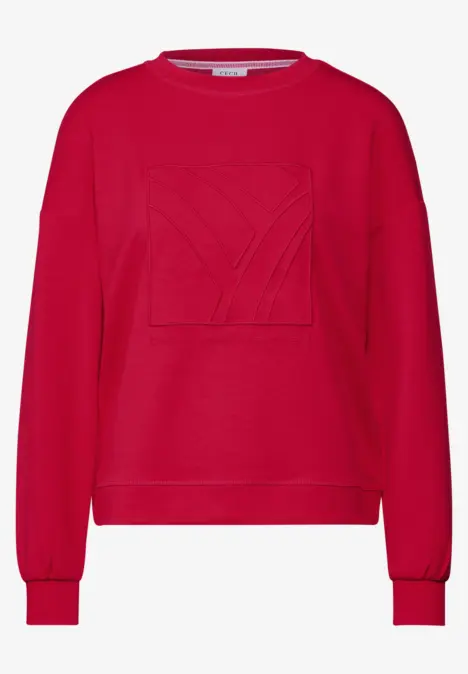 Roter Pullover mit Rundhalsausschnitt und großem, gesticktem Muster auf der Brust.