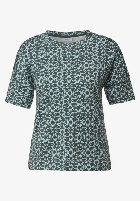 Kurzes T-Shirt mit mintgrünem, abstraktem Muster auf dunklem Hintergrund.