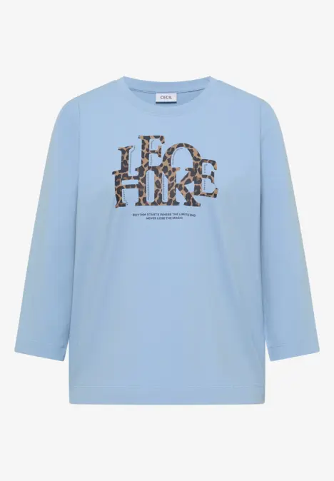 T-shirt bleu clair manches 3/4 avec imprimé animalier brun et noir formant un lettrage sur le devant.