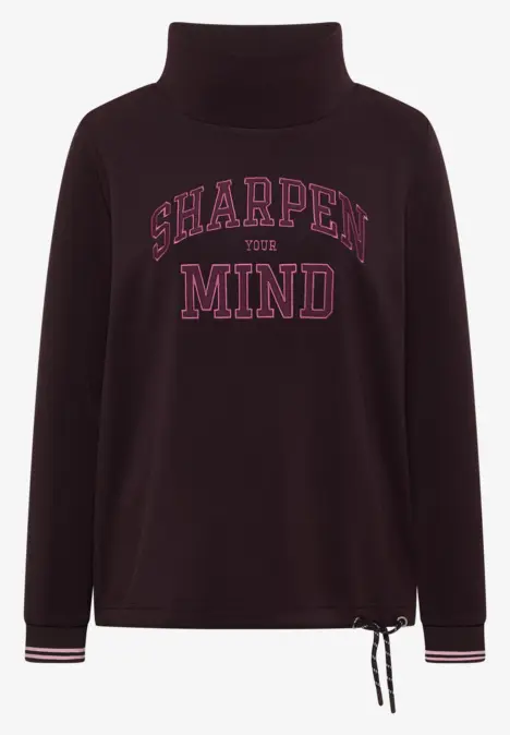 Dunkelvioletter Rollkragenpullover mit pinkem 'SHARPEN THE MIND'-Schriftzug, Saumkordel und gestreiften Bündchen.
