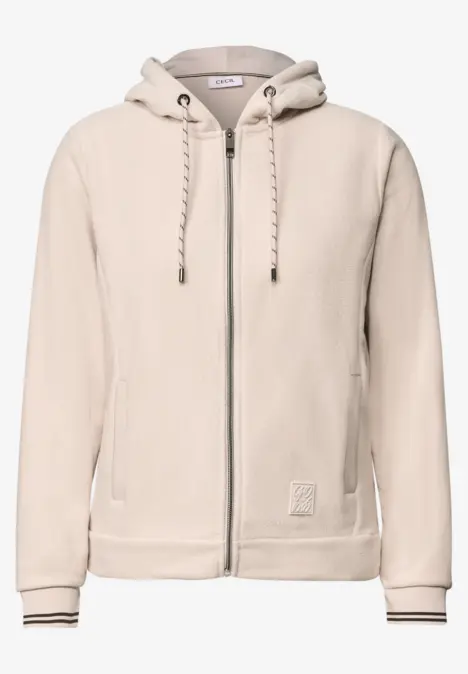 Helles, sandbeiges Hoodie aus weichem Stoff mit Reißverschluss, Kapuze und Kordeln, seitlichen Taschen.
