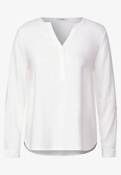 Blouse blanche à manches longues et col en V.