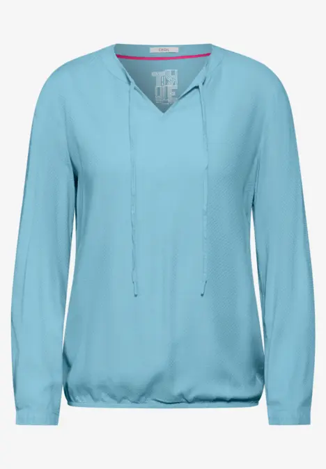 Hellblaue Bluse mit langen Ärmeln und V-Ausschnitt.