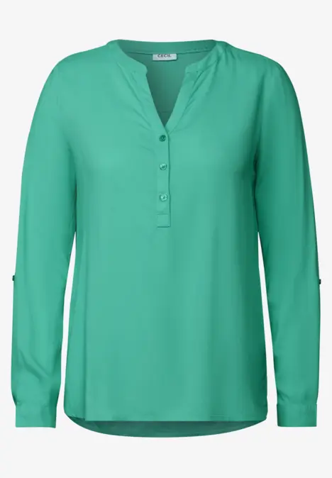 Grüne Bluse mit langen Ärmeln und Knopfleiste vorne.