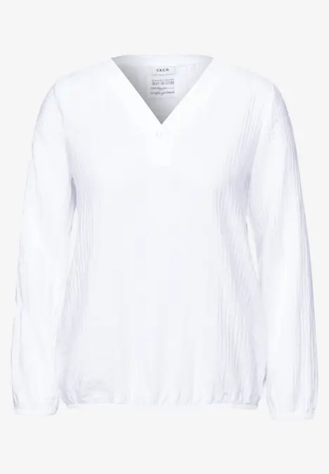 Weiße Bluse mit V-Ausschnitt und langen Ärmeln.
