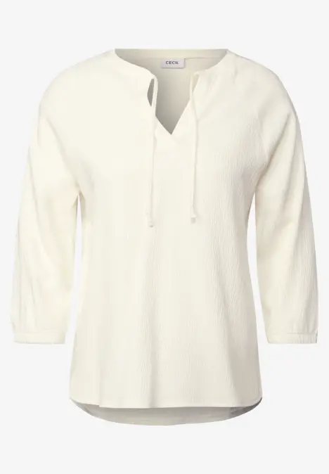 Weiße Bluse mit 3/4-Ärmeln und V-Ausschnitt.
