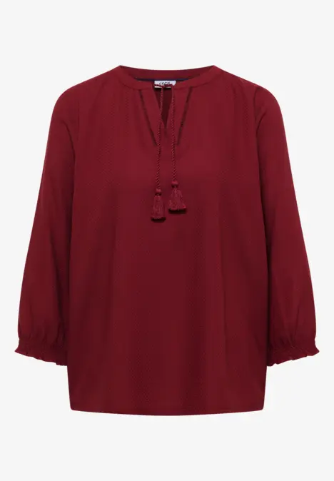 Elegante burgunderrote Bluse mit 3/4-Ärmeln und Quasten am Ausschnitt.