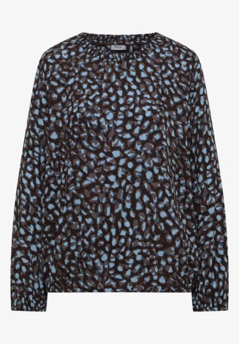 Damenbluse mit schwarzem Grund und blauem abstraktem Blattmuster, langärmlig, locker geschnitten.